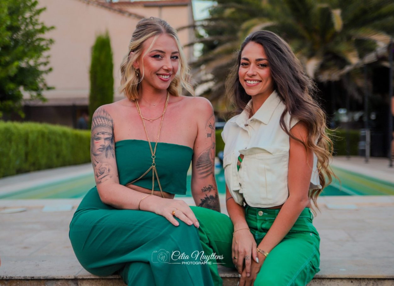 Photographe pour mariage Un couple souriant coupe un gâteau de mariage au milieu d'une célébration.